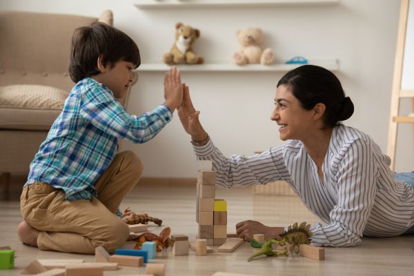 Child and parent high fiving over blocks