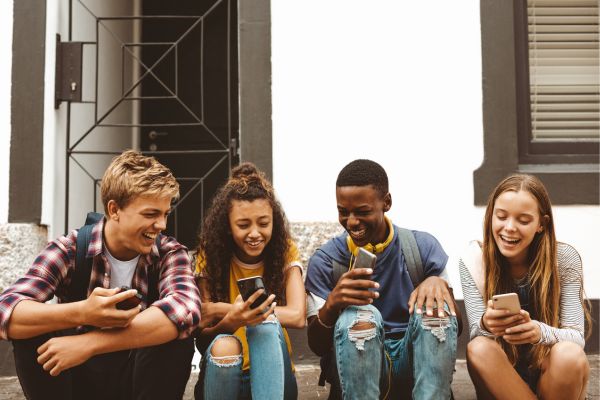 Teens sitting together and looking at their phones Find a relatable and trustworthy teen therapist for this transitionary period of life. We help with everything from self-esteem to mood disorders and more.