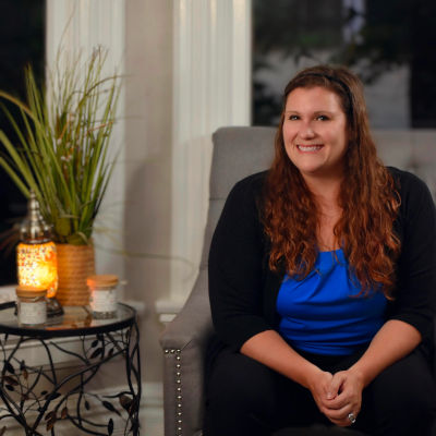Photo of Jenna McLaughlin sitting in a chair at her family therapy clinic in Algonquin.